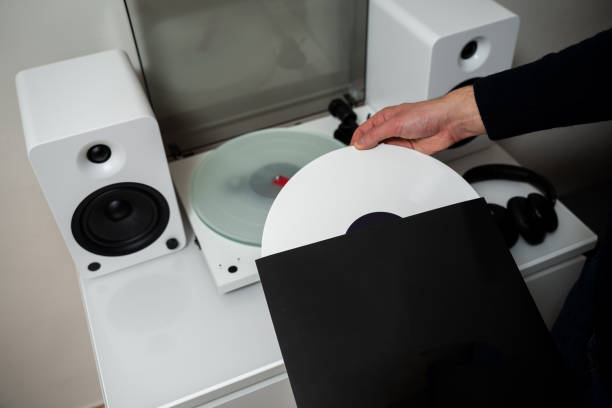 istock Vinyl LP tracks with modern needle player. Musician changes vinyl record into turntable player and speaker system. 2201438882