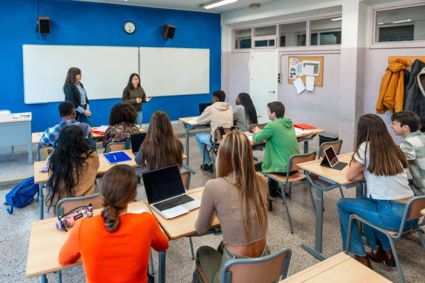 istock High school students listening to teacher's presentation in classroom 2201440848