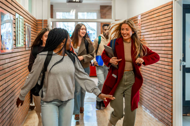 istock Cheerful students running in school hallway 2201441245