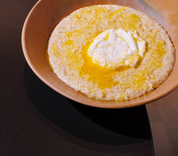 istock Creamy polenta being served with poached egg and grated cheese in a rustic bowl 2201442509