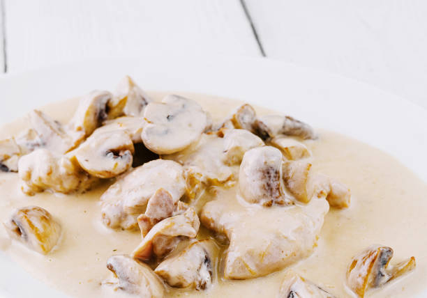 Chicken breast pieces in a creamy mushroom sauce, served on a white plate