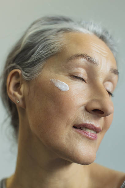 istock Mature woman with cream on face 2201445945