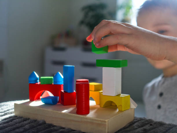 istock geometric wooden colorful figures close up with boy 2201449496