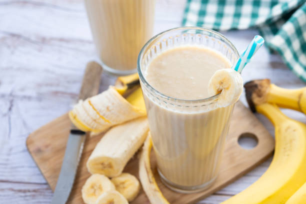 istock Fresh banana smoothie on white wooden table 2201451154