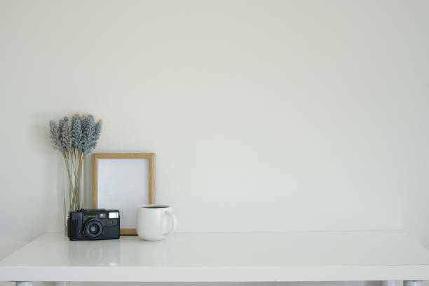 istock Minimalist desk with a retro camera, delicate lavender flowers, and a coffee mug. 2201451273