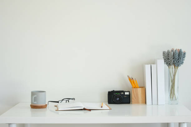istock Modern white desk with a gray coffee mug, an open notebook and glasses 2201451286