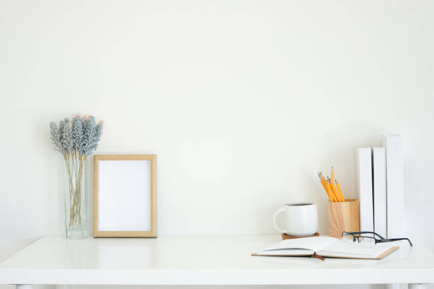 istock Empty wooden photo frame, coffee mug, and lavender flowers on white working desk. 2201451492