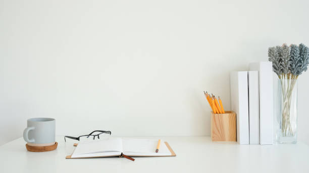 istock Workspace with open notebook with a pencil, glasses and coffee mug on a cork coaster. 2201451507