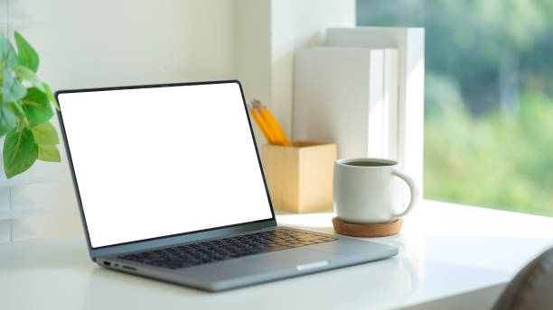 istock Workspace featuring a laptop, a cup of coffee, and neatly arranged stationery, complemented by a potted plant for a refreshing and inspiring environment. 2201451545