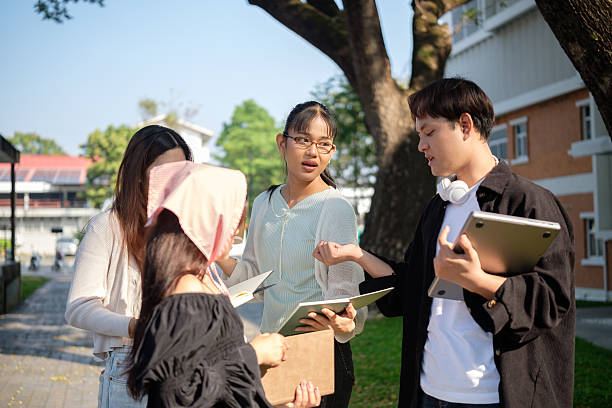 istock Young university students discussing assignments together outdoors on campus. 2201451893
