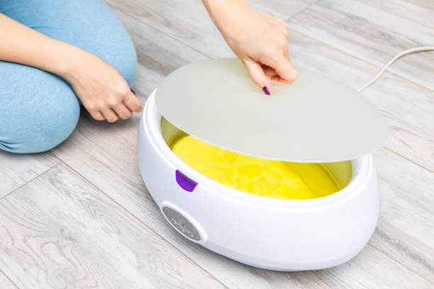 istock spa master applies paraffin in wax machine 2201454008