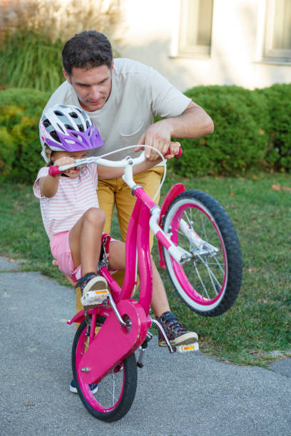 istock Little girl learning how to ride a bike 2201459537