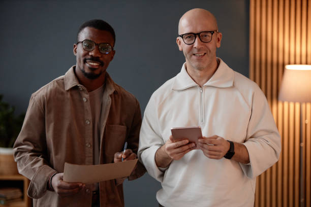 istock Diverse Team of Two Male Designers with Tablet Smiling at Camera while Standing in Office 2201460243