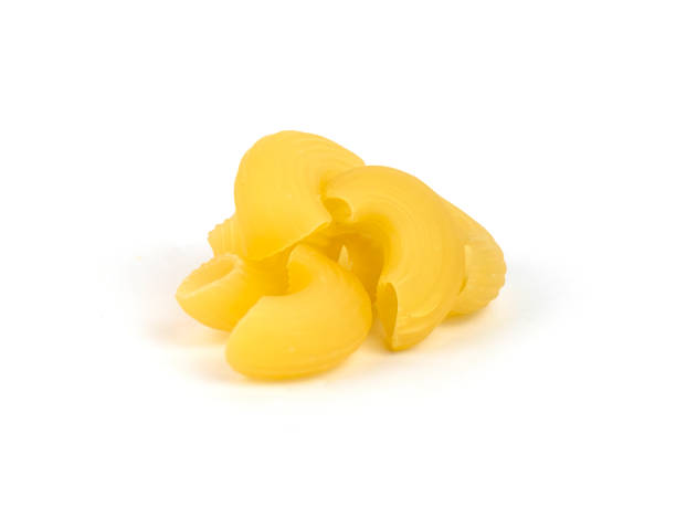 istock Curved pasta shapes are stacked in a neat pile on a white surface 2201461484