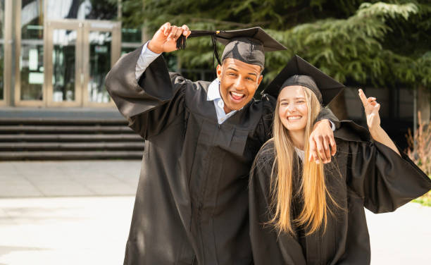 istock Two multiethnic happy college graduates celebrating graduation day 2201461507