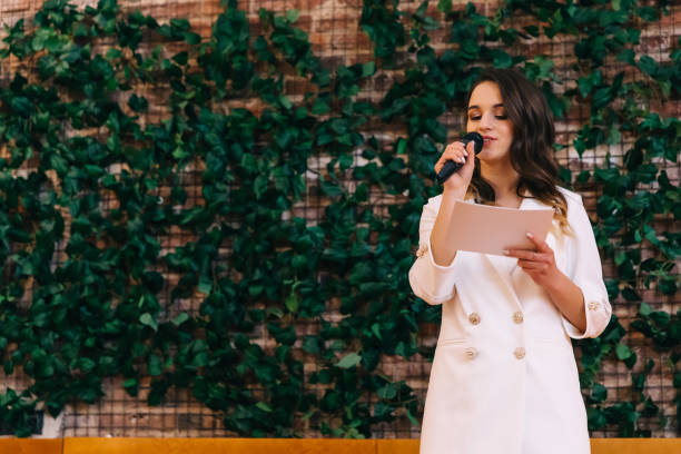 istock Master of ceremonies in a white reads a speech and holds the mic 2201462131
