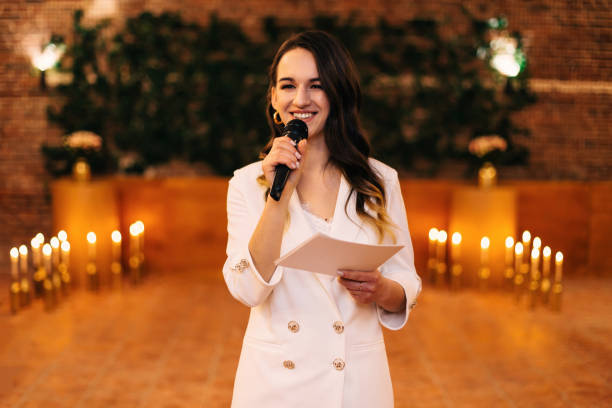 istock woman holds microphone and speech. beautiful smile and festive c 2201462215
