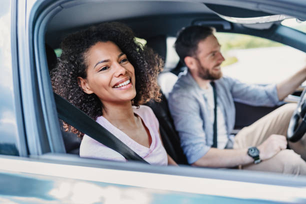 istock Smiling young woman looking through an open car window 2201469915
