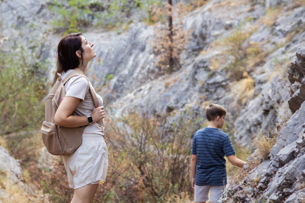 istock Connecting with nature. Mother and son exploring forest.  Precious family moments while enjoying their adventure in parkland. 2201471056