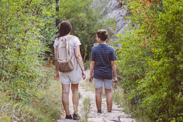 istock Connecting with nature. Mother and son exploring forest.  Precious family moments while enjoying their adventure in parkland. 2201471459