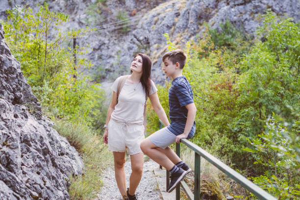 Connecting with nature. Mother and son exploring forest.  Precious family moments while enjoying their adventure in parkland.