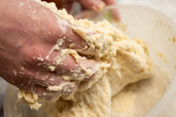 Woman hands mixing dough in a plastic bowl, soft focus