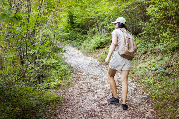 Connecting with nature. Woman backpacker exploring forest.  Precious moments while enjoying her adventure in parkland.