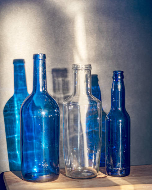 istock Still life with blue glass bottles, quiet shadows in the background, soft evening light 2201477234