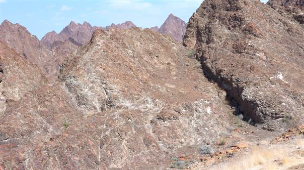 istock Rocky desert unfolds between mountains, rocky slopes reflecting erosion patterns, mountains standing firm against erosion, dry ground carved by erosion, rocky surface glowing under sunlight. 2201479137