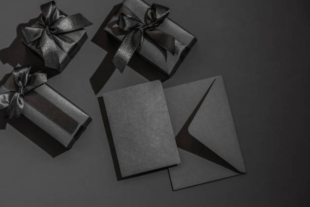 istock Black gift boxes and a black envelope on a dark black background with space for text. Congratulations, postcard. 2201479152