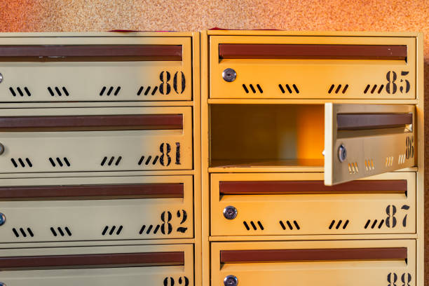 Man's hands posting a letter in a yellow post box