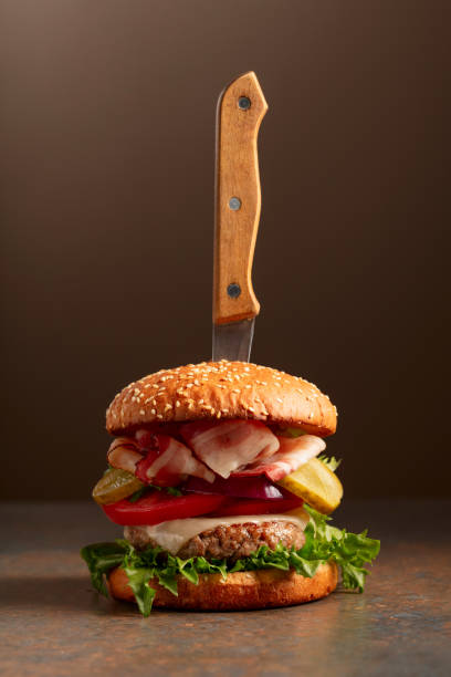 istock Fresh burger with knife on a brown background. 2201480022