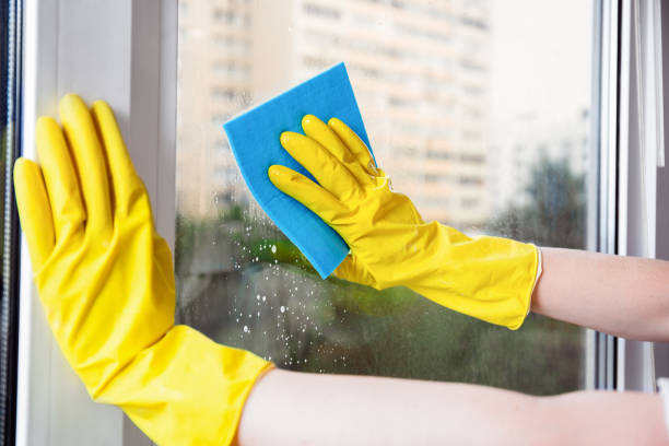 istock Hands In Yellow Gloves Cleaning A Window With Sponge Cloth 2201483239