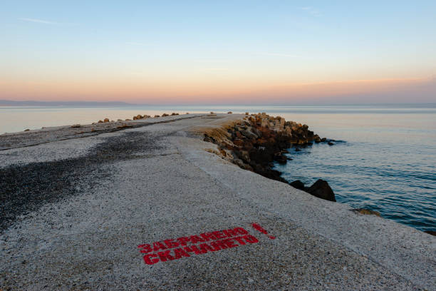 Stone pier in Pomorie town, just before the subset. Burgas district, Bulgaria, Europe. The sign is in Bulgarian and  means \