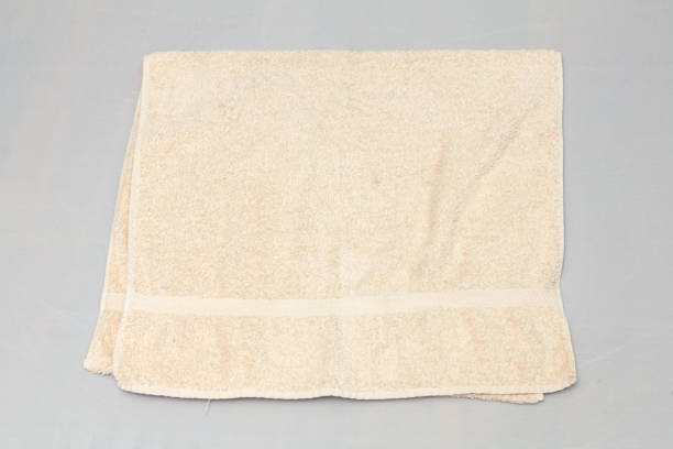istock Folded beige towel on gray background representing hygiene and comfort 2201484586