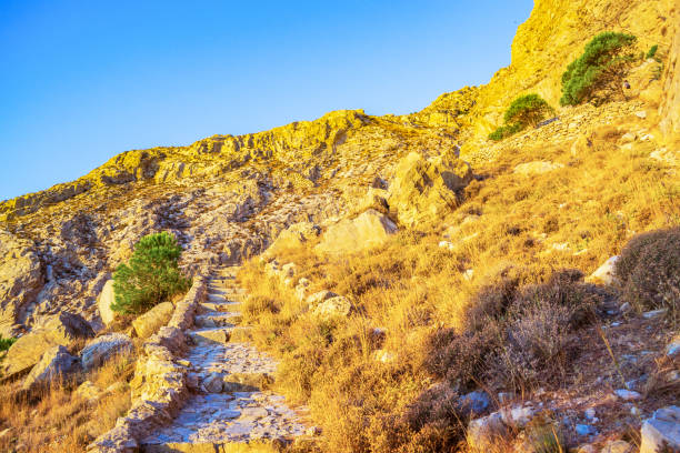 Hiking trail at  Mesa Vouno mountain on sunrise.Kamari is a village and resort at Santorini, a Greek island known for its rugged volcanic landscapes