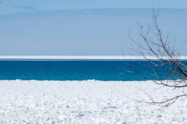 Aerial view capturing a scientist walking across a frozen lake, collecting ice samples for research during a polar expedition in the frigid arctic wilderness