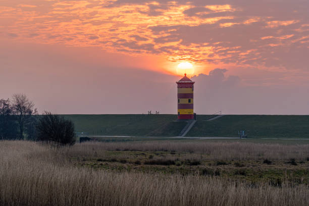 Pilsum, Germany - February 9, 2025: Lighthouse of Pilsum during sunset on February 9, 2025 in East Frisia, Germany