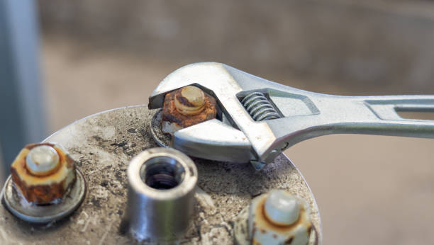 istock Adjustable wrench used to loosen a rusty bolt on a metal surface. 2201495837