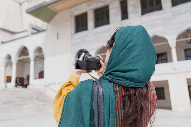 Young Muslim woman taking photos while traveling