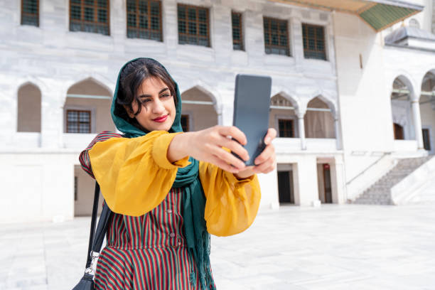 istock Young Muslim woman taking selfie while traveling 2201496679