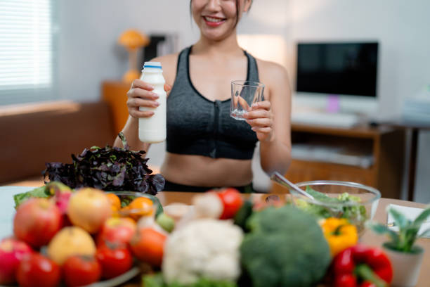 istock Young woman pouring milk, preparing nutritious meal with fresh produce in sleek kitchen, embodying healthy, vibrant eating lifestyle 2201498121