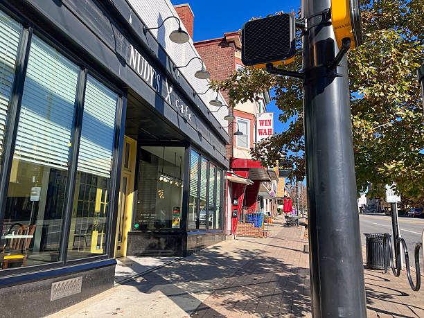 Philadelphia, PA. USA - Nov 13th 2024: A street scene with a black pole and a traffic light. The pole is next to a building with a sign on it that says Nudy's Cafe.