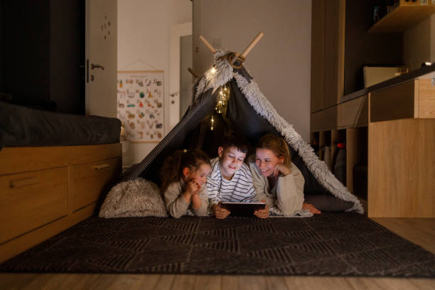 Family Bonding with a Digital Tablet in a Cozy Blanket Fort