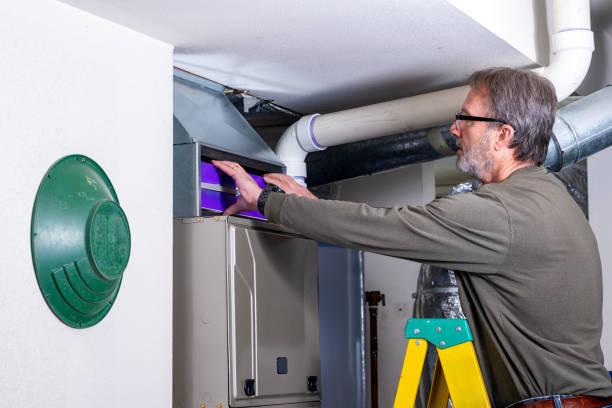 istock Home owner removes an old filter from furnace 2201511252