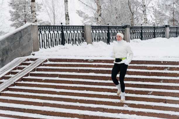 istock young caucasian woman runs in park in winter 2201511345