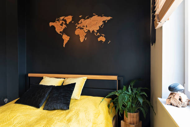 istock Yellow and black pillow on comfortable double bed in modern bedroom. Black wall with decoration in hotel room in cosy interior. 2201516021