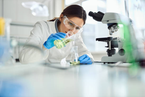 istock Young female scientist mixing chemical substances in laboratory. 2201517343