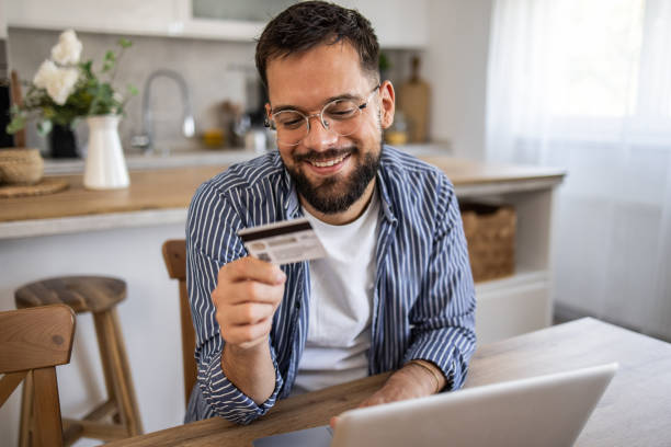 istock Man browsing online stores and shopping at home 2201517972