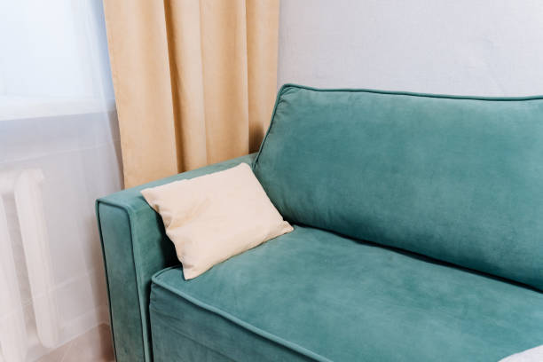 istock In a cozy and inviting living room, a charming blue couch adorned with a soft white pillow resting on its arm creates an ideal and serene atmosphere for unwinding and complete relaxation 2201519156